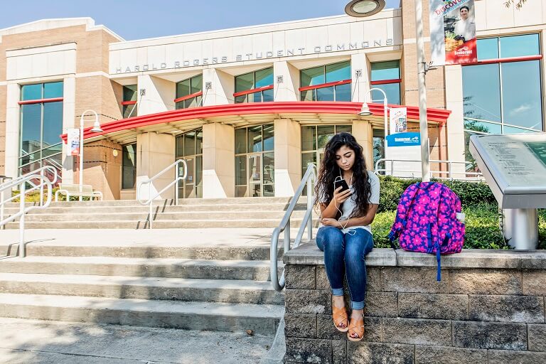 Female student in sitting outside scc building