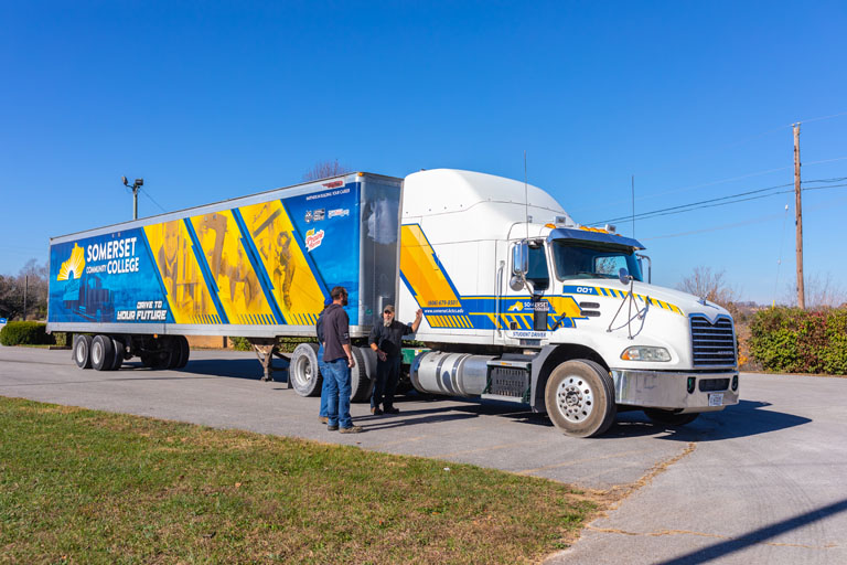 student standing in front of an SCC semi-truck
