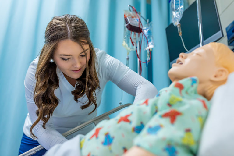 Student leaning over a mannequin
