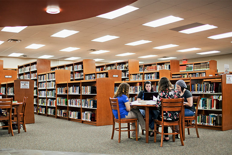 group of students studying at a table in the learning commons